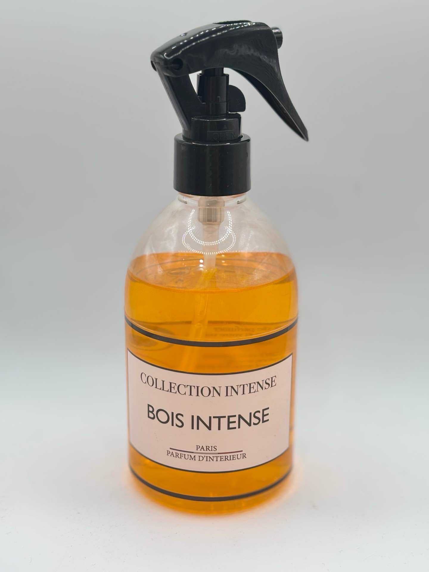 Heldere glazen roomsprayfles met zwart spuitmondje gevuld met amberkleurige parfum collection intense bois intense paris
